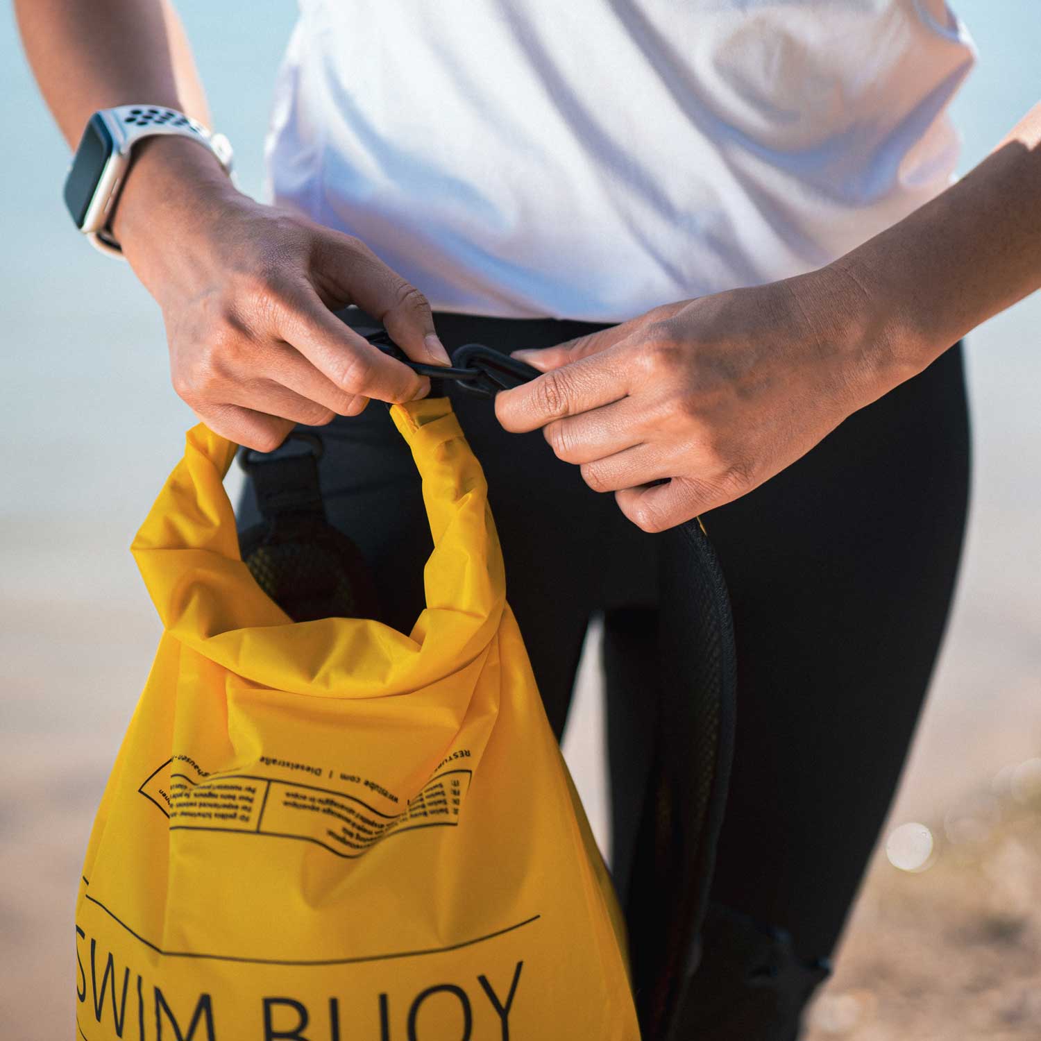 woman attaching the packbackstraps to the swim buoy
